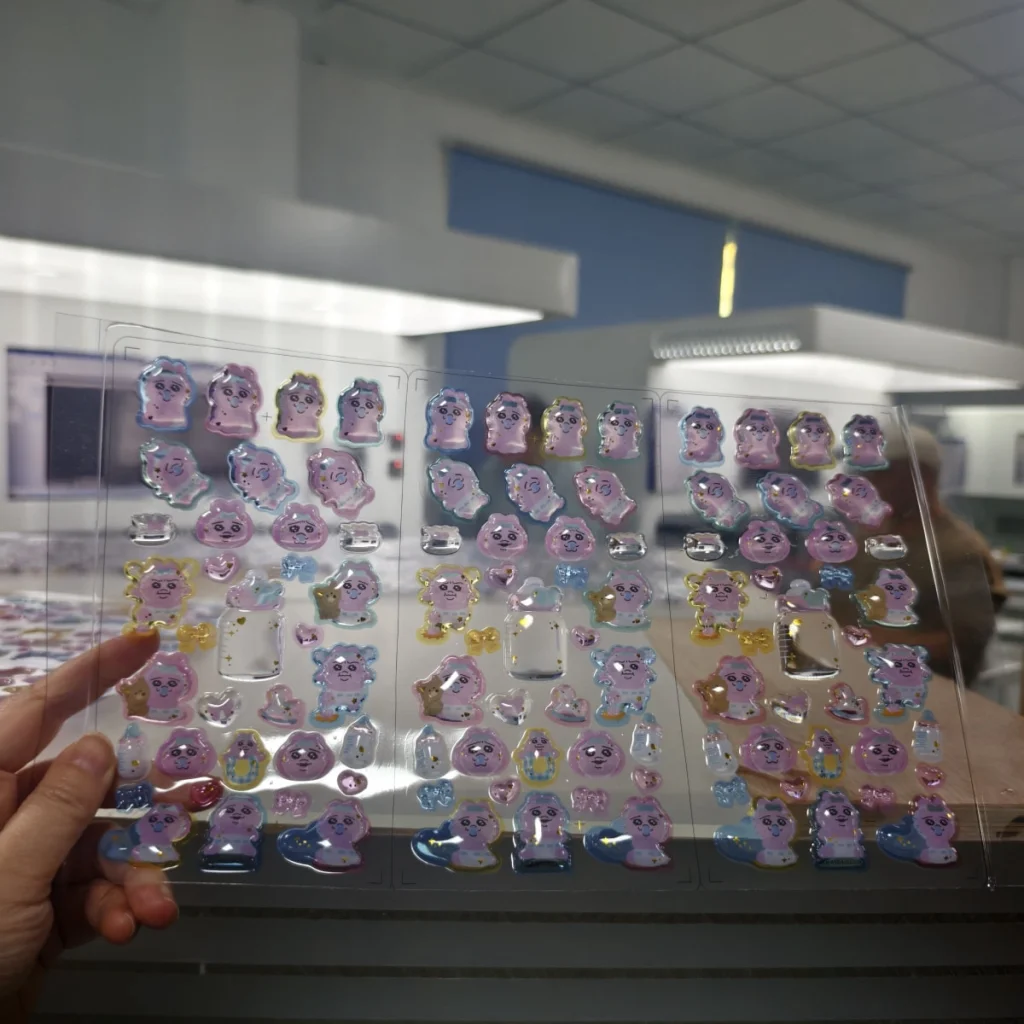 3D滴胶贴纸制作方法 操作员手持完成的树脂滴胶贴纸整版进行质量检查