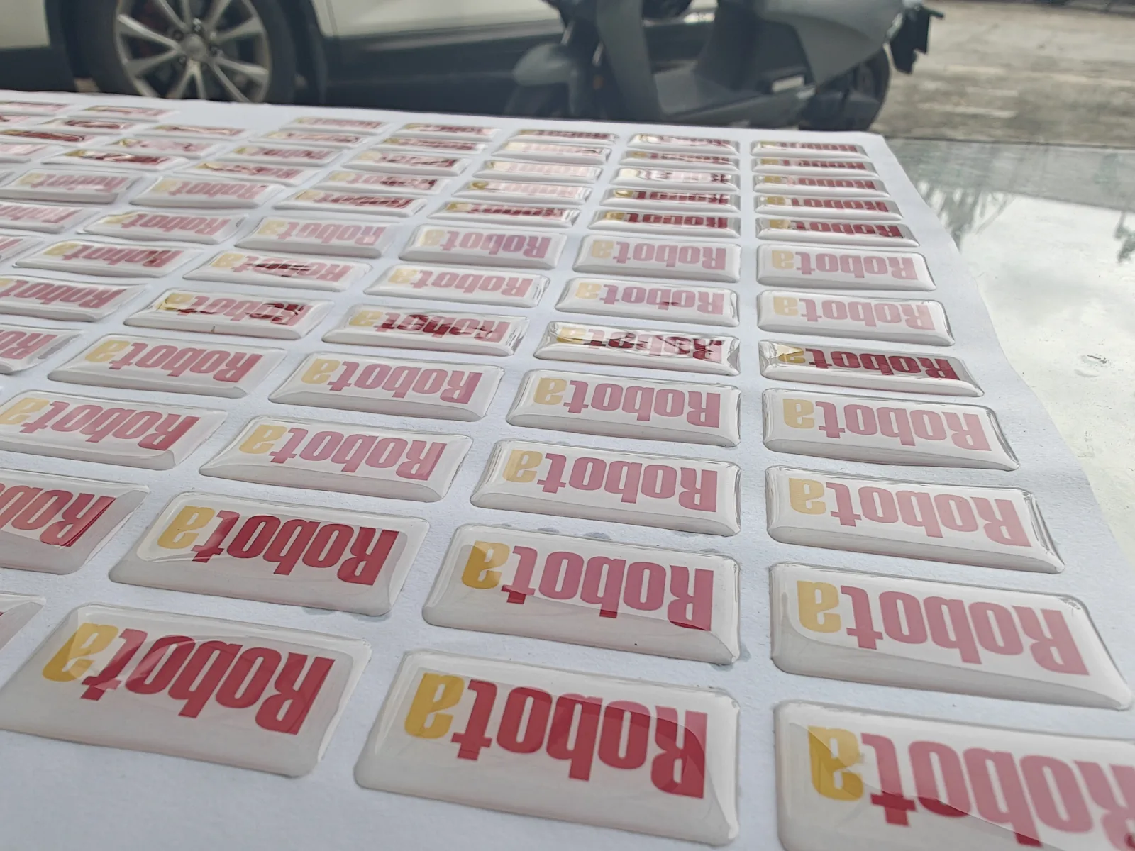Finished domed logo labels with visible print and color irregularities on one sheet