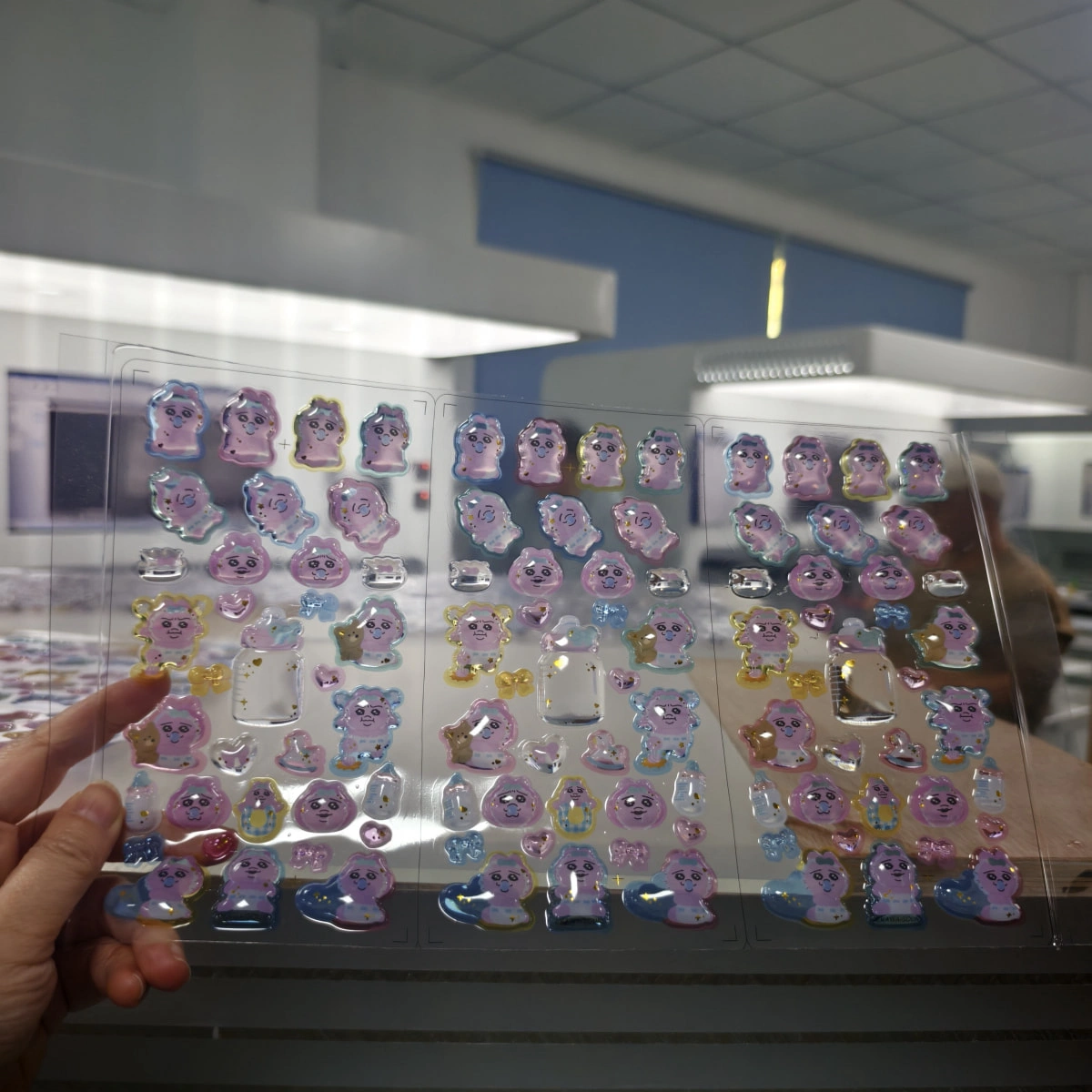 Doming Machine Sample Test and Acceptance Checklist Visual inspection of a cured resin-domed sticker sheet under controlled lighting