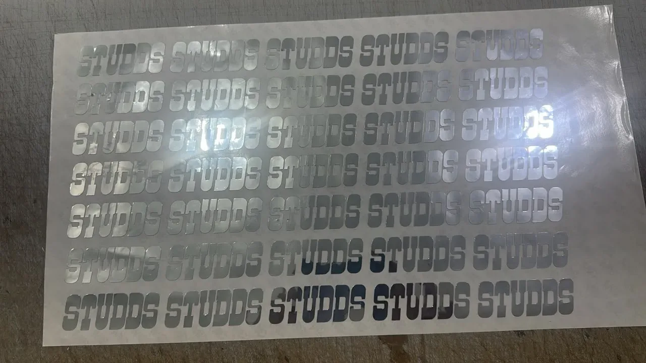 Metallic logo label sheet with a regular repeat layout for pre-dispense evaluation