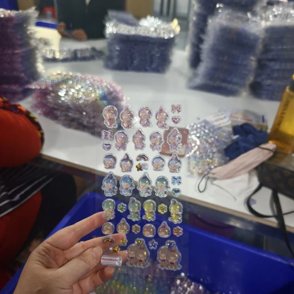 Temperature, Humidity, and Cure Time in Resin Doming Operator visually inspecting clarity and surface appearance of a domed sticker sheet
